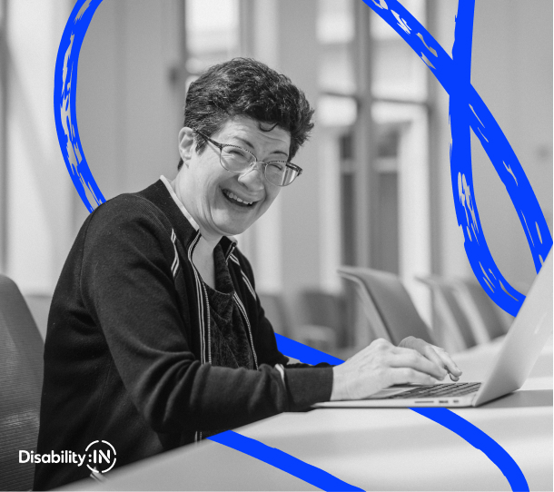 Woman smiling while typing on a laptop