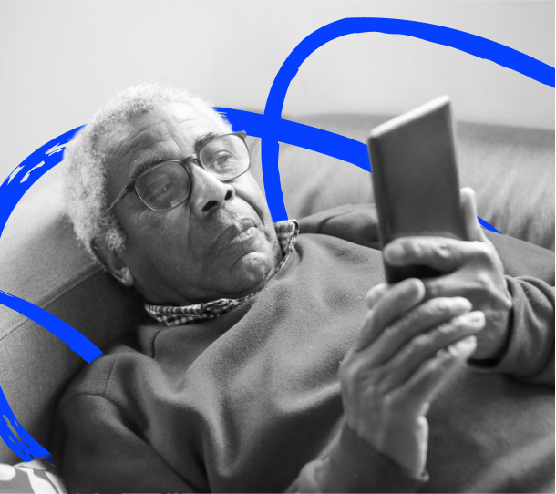 A person lying down on a couch and using a smartphone