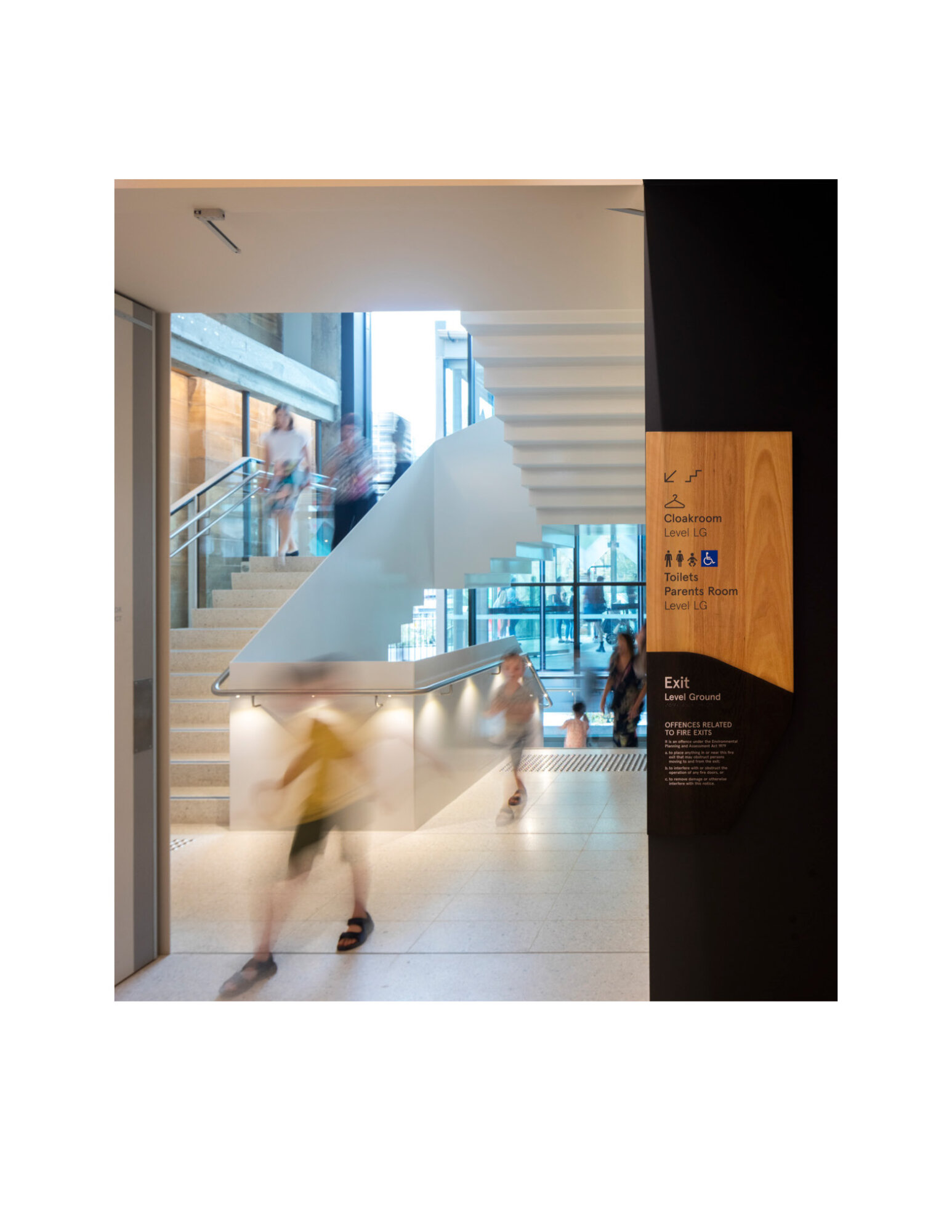 Directional hallway signage with pictograms on wood.