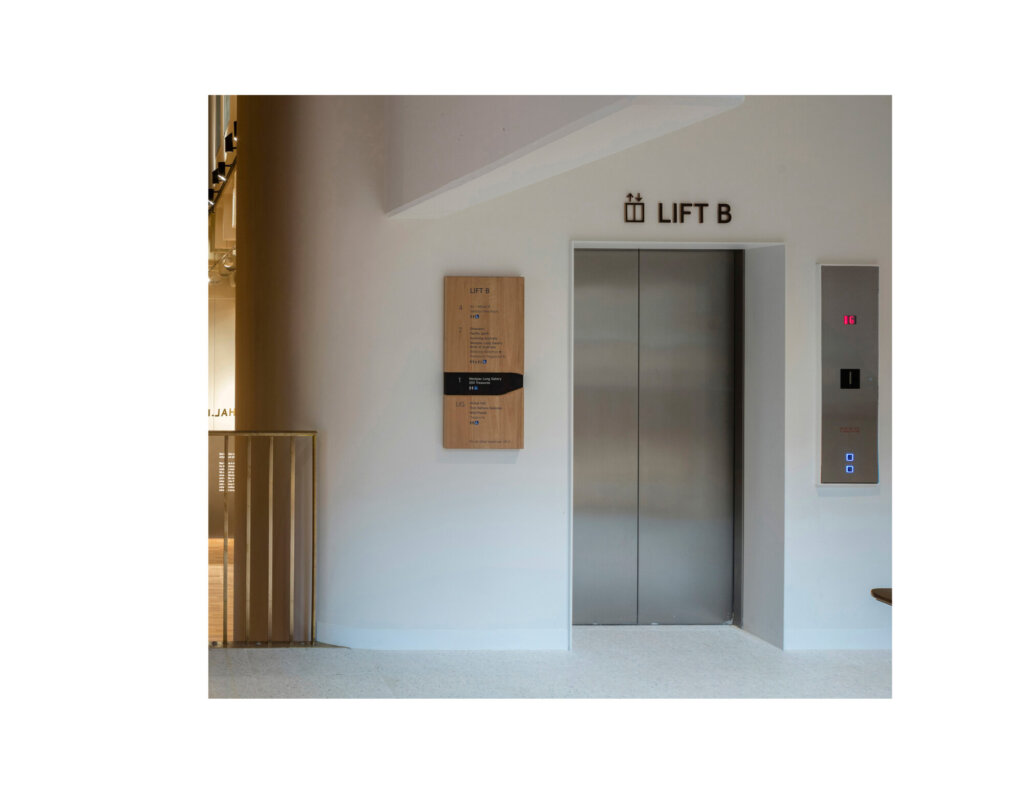 Directional signage next to elevator.