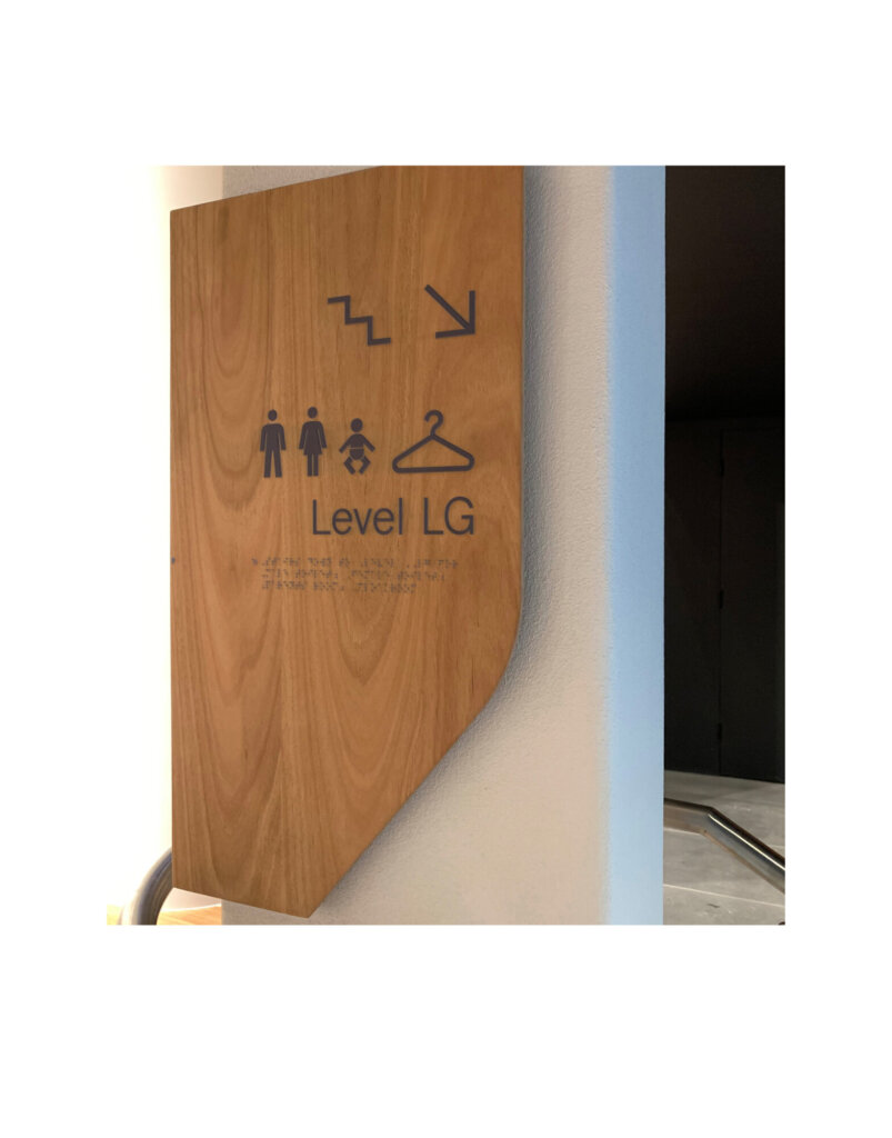 Directional signage using pictograms for washrooms and coat check.