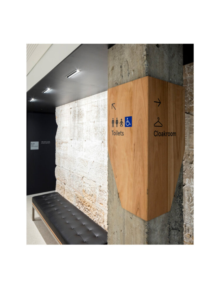 Directional signage using pictograms for washrooms and coat check.