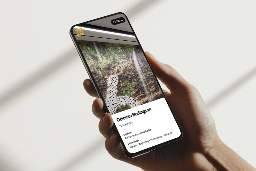 Man holding mobile phone with forgemedia.ca website displayed.