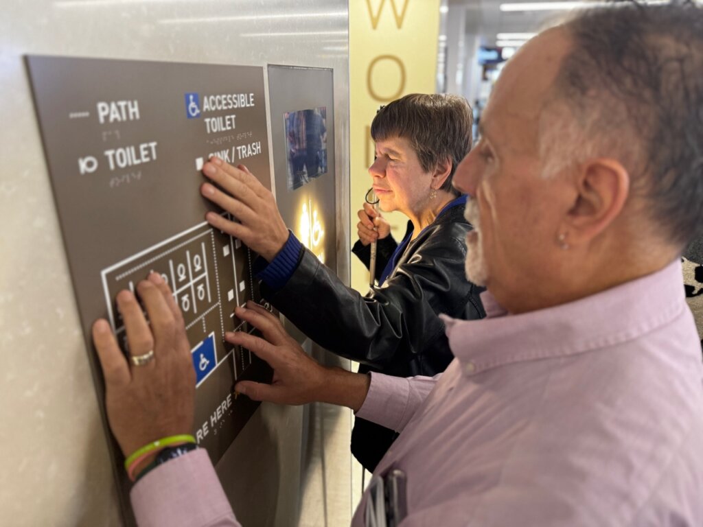 Two people who are blind use a tactile map