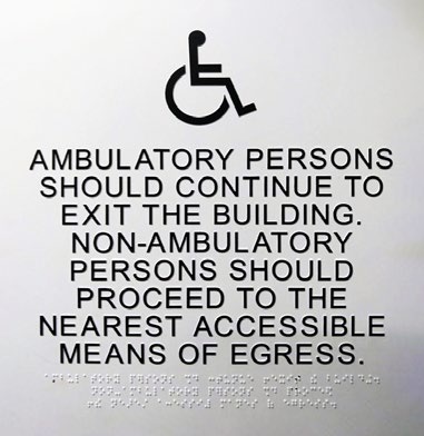 Language usage. This sign uses an internationally recognized raised symbol, raised lettering, braille, and a high degree of colour contrast, yet it’s an accessibility failure because of the language usage.