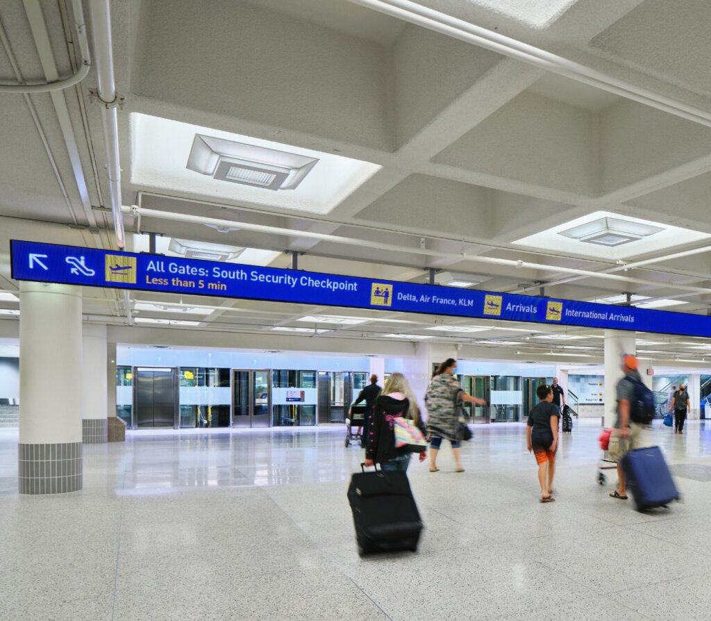 Overhead signage guiding travellers to the departure and arrival areas.